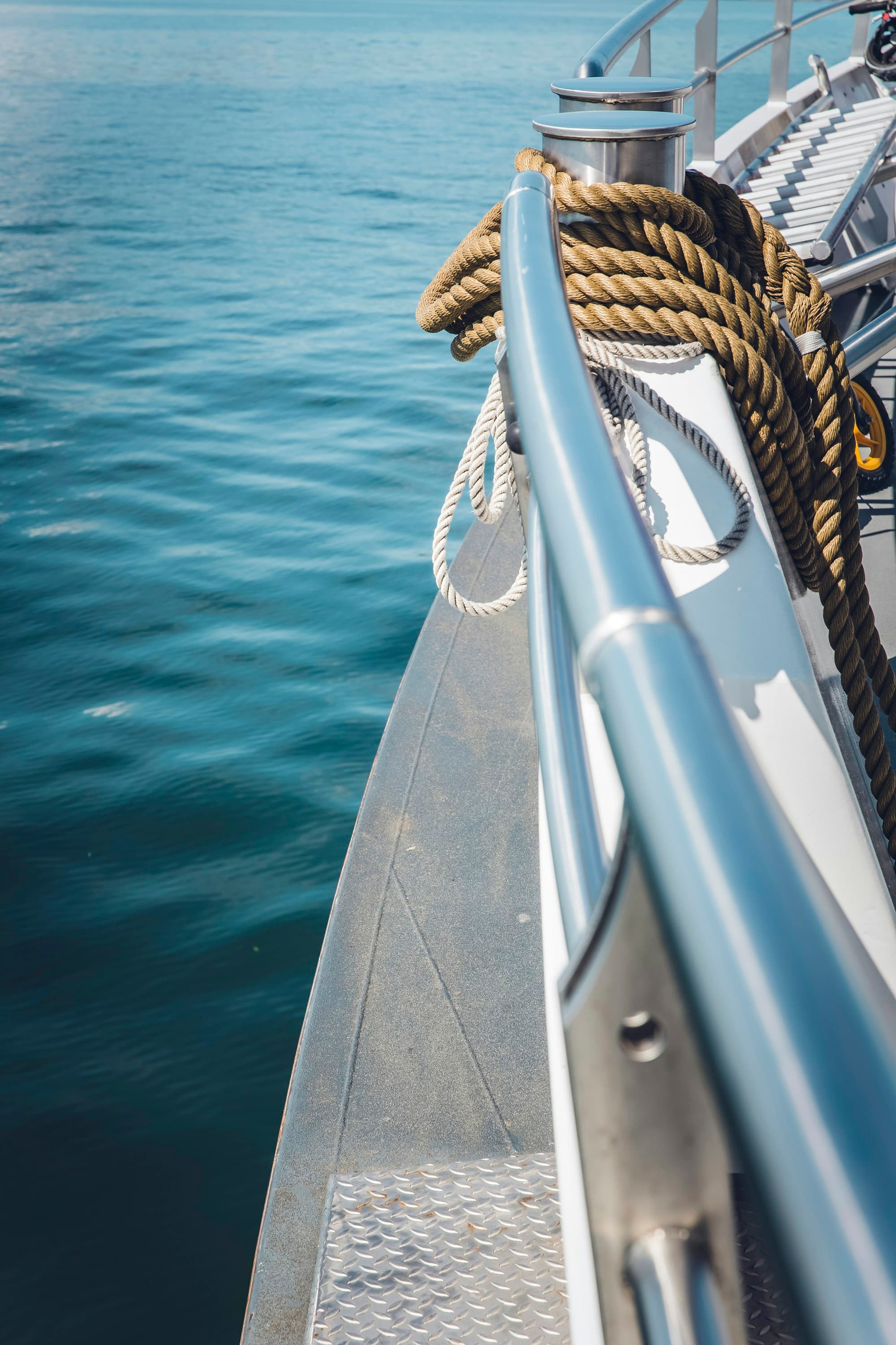 Mooring lines and polished deck hardware beside the water