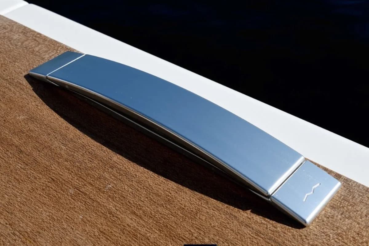Polished cleat sitting flush against a teak deck edge
